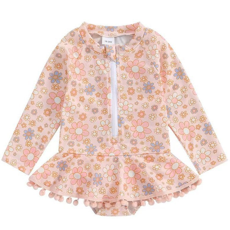 Girls' Long Sleeve Daisy Print Rash Guard Swimsuit with Pom-Pom Ruffle Skirt – Sizes 18 Months–6 Years